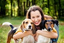 A woman hugging two dogs
