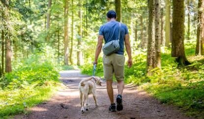 A photo of a man walking a dog